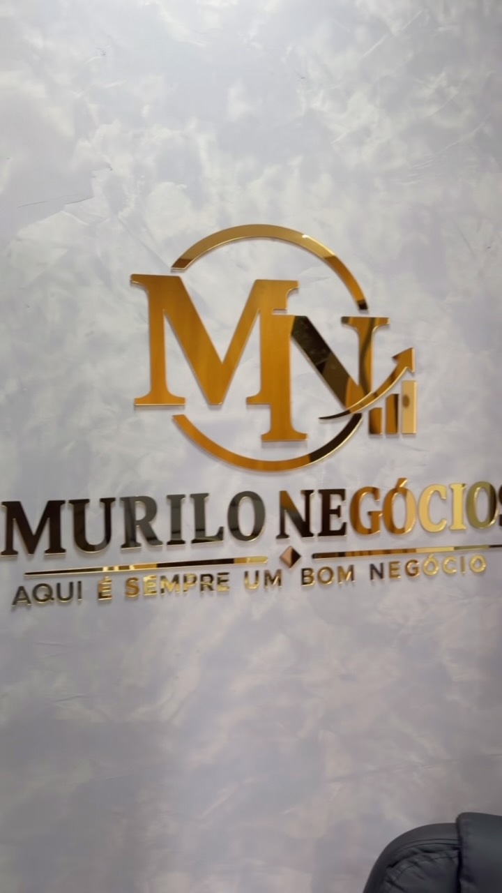Letreiro dourado Murilo Negócios na parede de mármore da loja